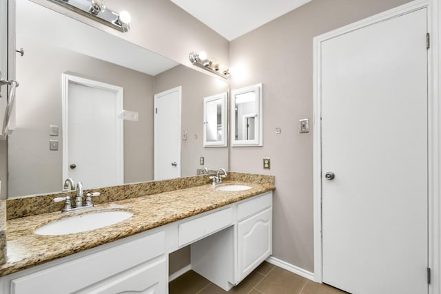 full bathroom featuring double vanity, a sink, baseboards, and tile patterned floors