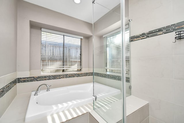 bathroom featuring a garden tub and a stall shower