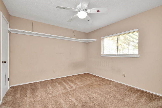 spare room featuring a textured ceiling, ceiling fan, carpet flooring, and baseboards