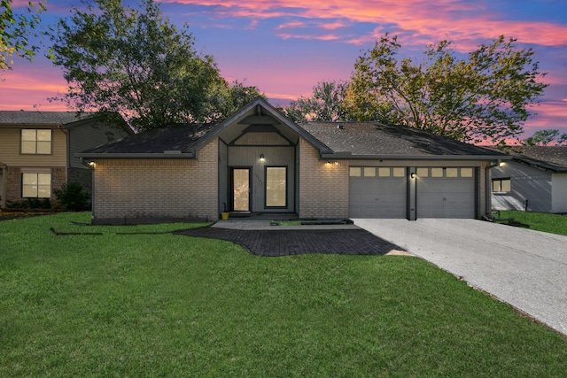 mid-century modern home with an attached garage, a front lawn, concrete driveway, and brick siding