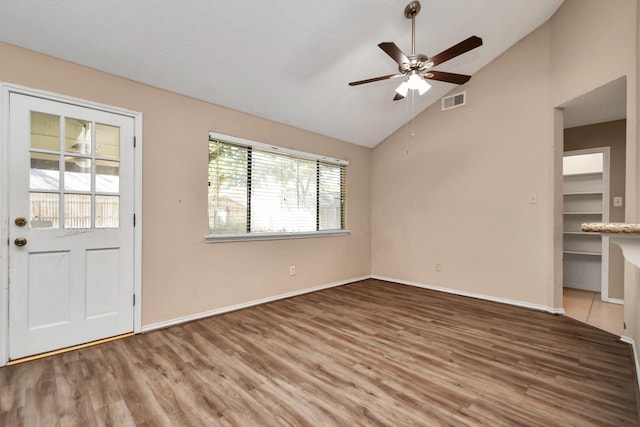 interior space featuring baseboards, visible vents, lofted ceiling, ceiling fan, and wood finished floors