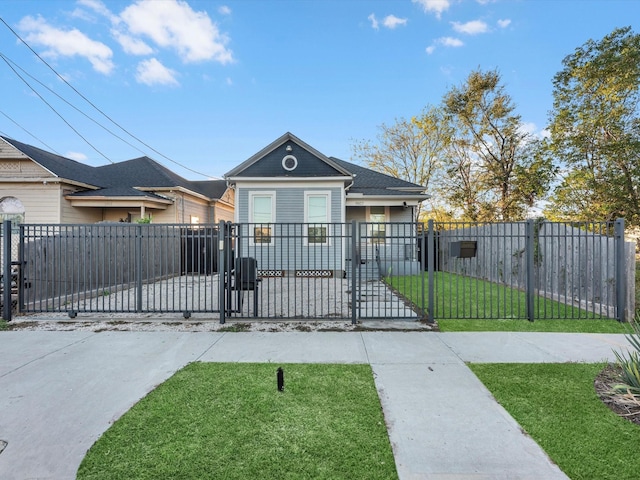 view of front facade featuring a front lawn, a fenced front yard, and a gate