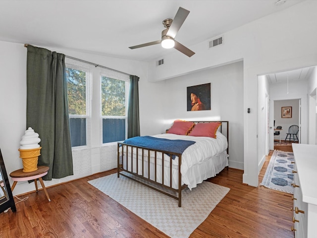 bedroom featuring attic access, visible vents, and wood finished floors