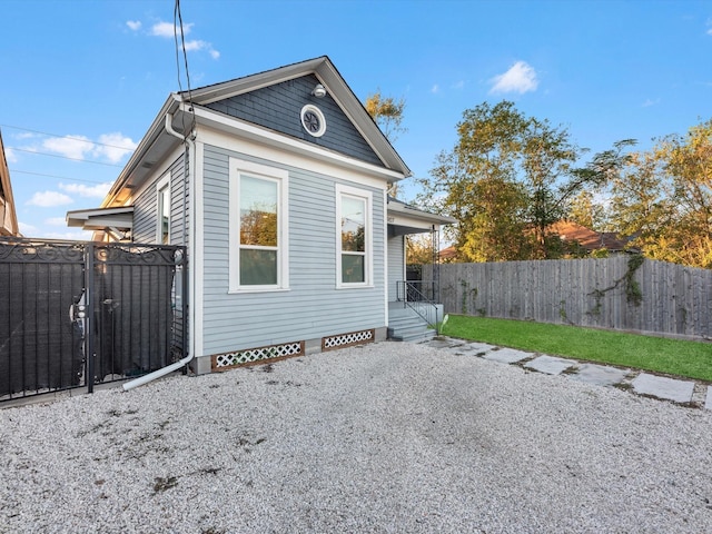 back of house featuring a gate and fence