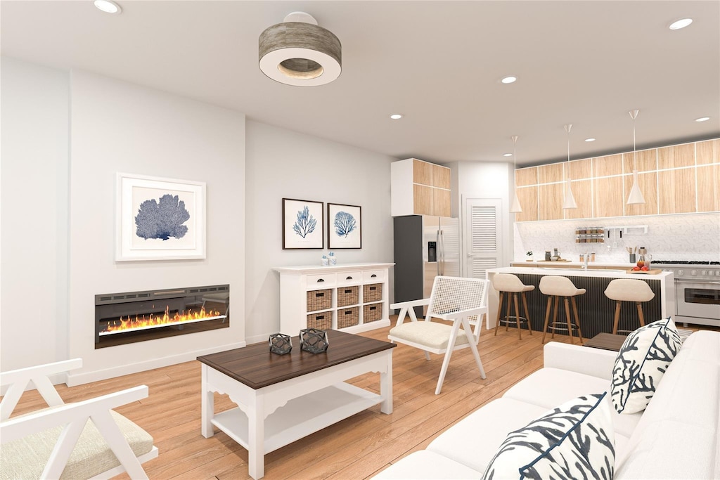 living room featuring baseboards, light wood-type flooring, a glass covered fireplace, and recessed lighting