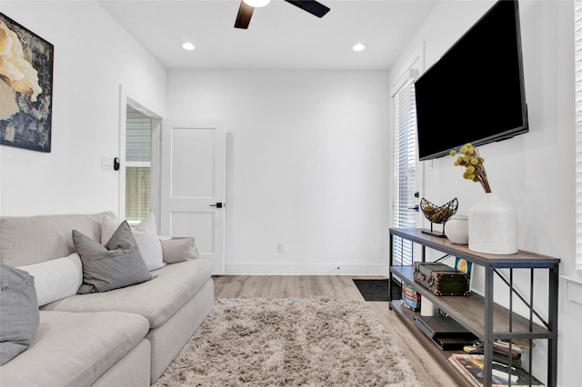 living area featuring light wood finished floors, baseboards, a ceiling fan, and recessed lighting