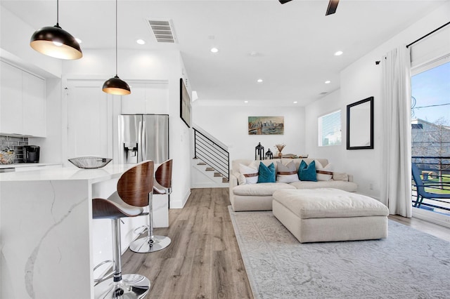 living area with light wood-style floors, stairs, visible vents, and recessed lighting