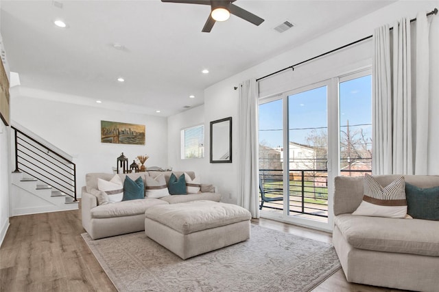 living room featuring recessed lighting, visible vents, stairway, and wood finished floors