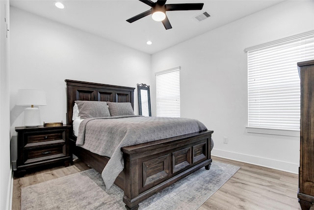 bedroom with light wood-style floors, recessed lighting, visible vents, and baseboards