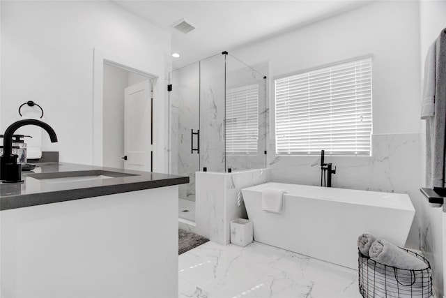 bathroom with a marble finish shower, visible vents, marble finish floor, a freestanding tub, and a sink