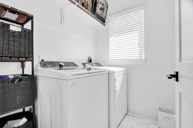 clothes washing area with washer and dryer, laundry area, marble finish floor, and baseboards