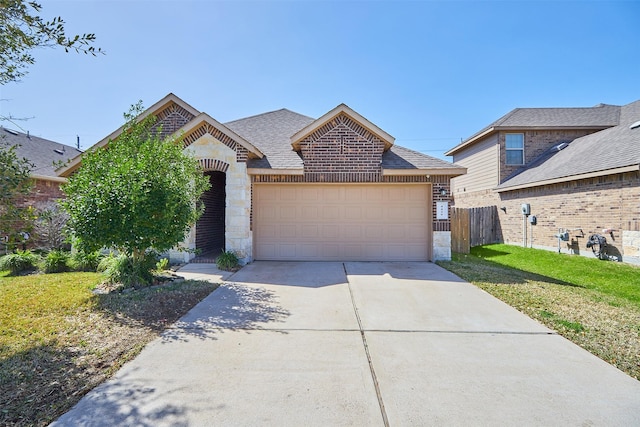 french provincial home with brick siding, fence, concrete driveway, stone siding, and roof with shingles