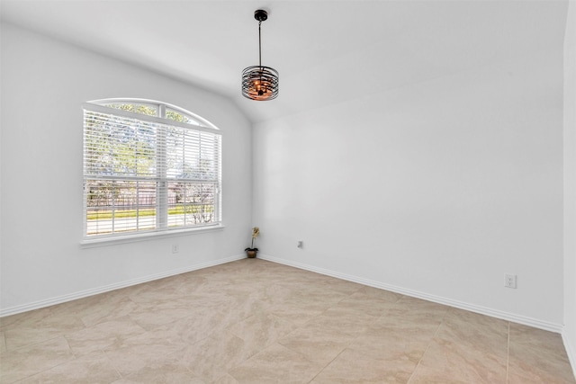 spare room with vaulted ceiling and baseboards