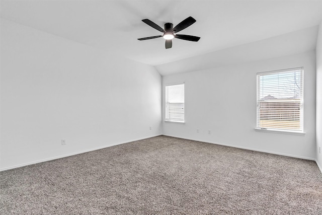 empty room with lofted ceiling, carpet floors, ceiling fan, and a healthy amount of sunlight