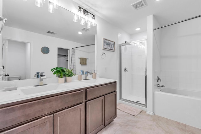 bathroom with double vanity, a stall shower, a sink, and visible vents