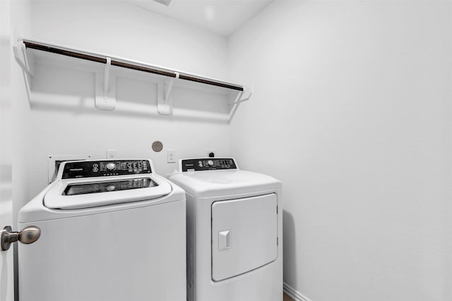 laundry room featuring laundry area, independent washer and dryer, and baseboards