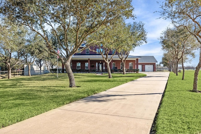 view of front of house featuring an attached garage, a front yard, concrete driveway, and brick siding