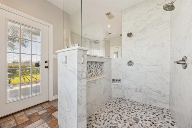 full bathroom with stone tile flooring, visible vents, and walk in shower