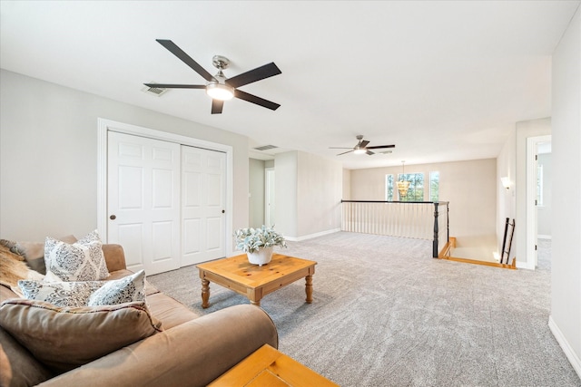 carpeted living room featuring ceiling fan, visible vents, and baseboards