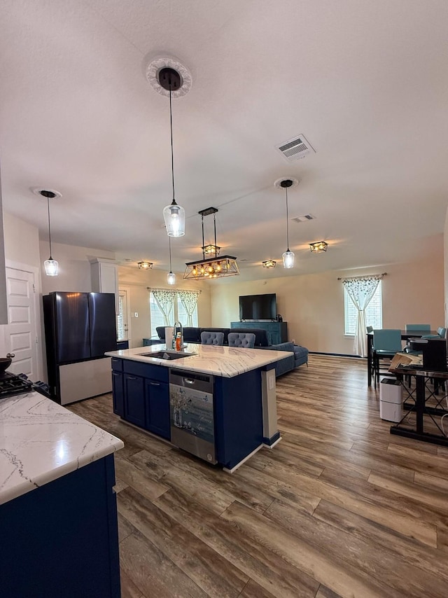 kitchen featuring dishwashing machine, blue cabinets, dark wood-style flooring, open floor plan, and freestanding refrigerator