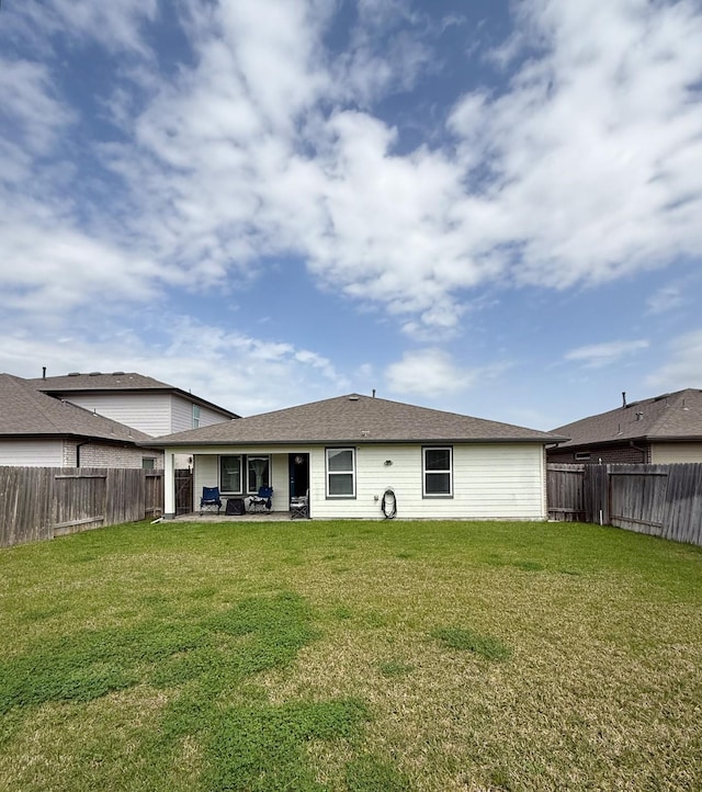 back of property with a fenced backyard, a lawn, and a patio