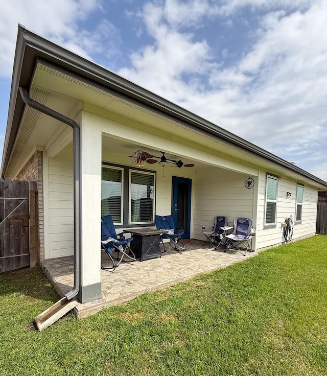 rear view of house featuring a yard, a patio, fence, and a ceiling fan