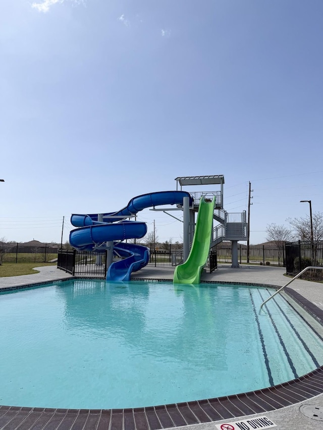 pool featuring a water slide and fence