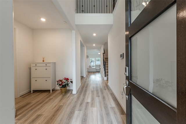 hall featuring stairway, recessed lighting, baseboards, and light wood finished floors