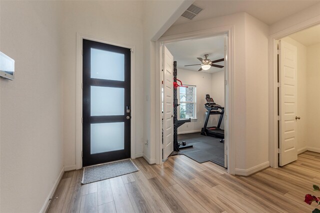 entrance foyer featuring light wood finished floors, visible vents, a ceiling fan, and baseboards