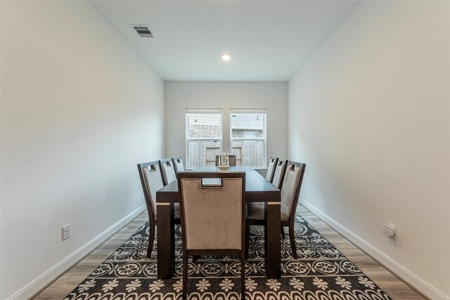 dining room featuring visible vents, light wood-type flooring, and baseboards