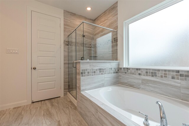 bathroom featuring a shower stall and a garden tub