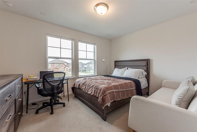 bedroom with light carpet and baseboards