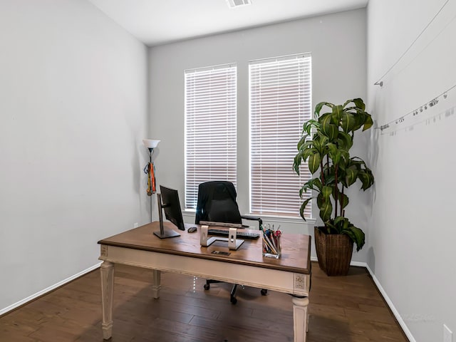 office space with wood finished floors, visible vents, and baseboards