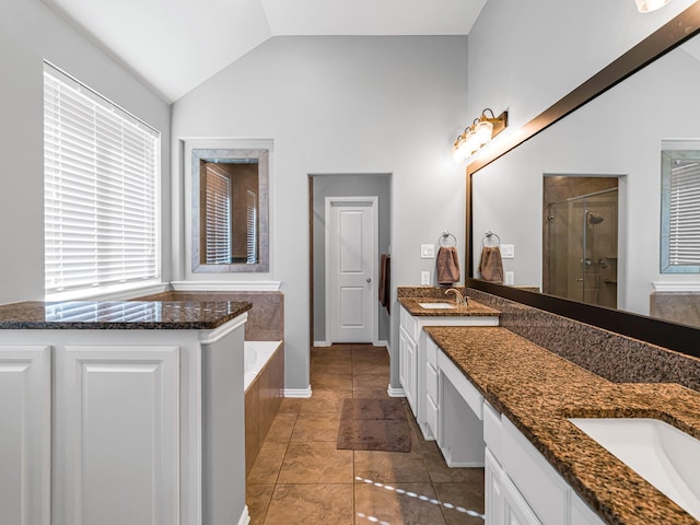 bathroom with lofted ceiling, two vanities, a sink, a bath, and a stall shower