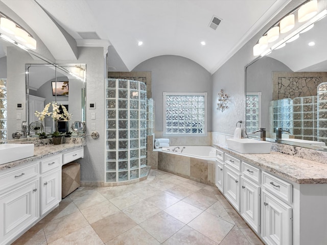 full bathroom featuring a garden tub, two vanities, a sink, vaulted ceiling, and walk in shower