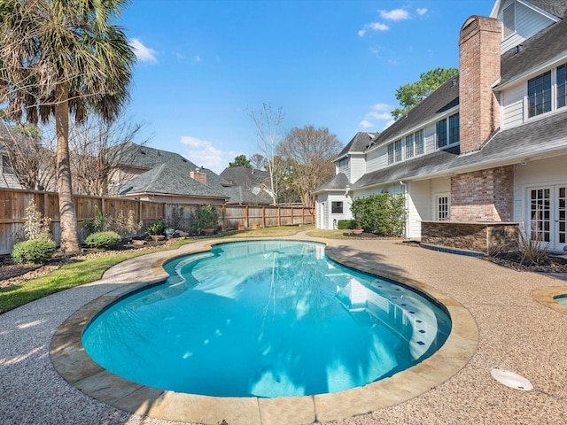 view of swimming pool featuring a fenced backyard and french doors