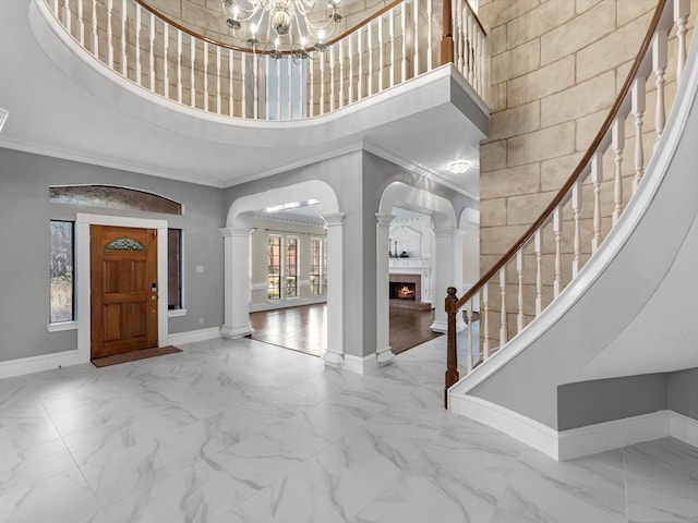 7714 Hertfordshire Dr, Spring, TX 77379 - entrance foyer with baseboards, a towering ceiling, marble look tile flooring, crown molding, and ornate columns