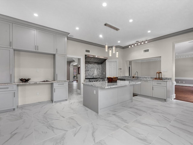 kitchen featuring gray cabinetry, visible vents, marble finish floor, a center island, and crown molding