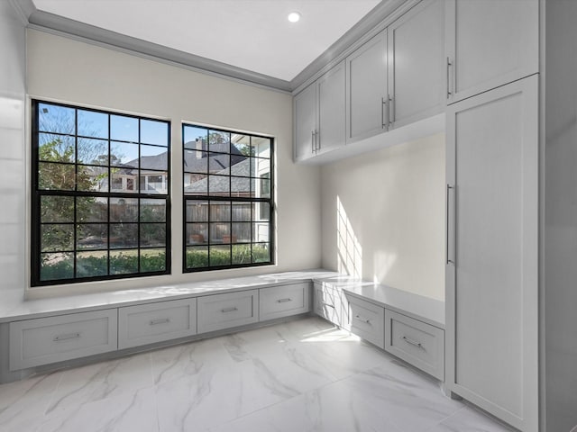 mudroom with marble finish floor, ornamental molding, and recessed lighting