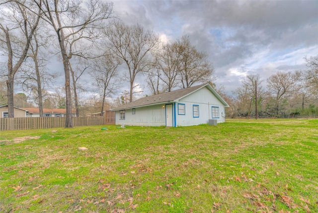 view of yard featuring central AC and fence