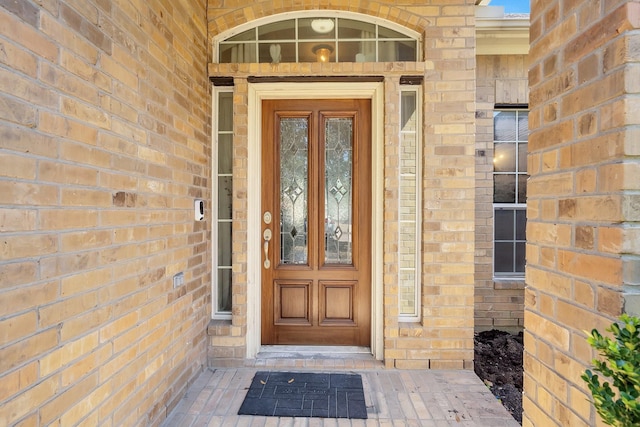 view of exterior entry featuring brick siding