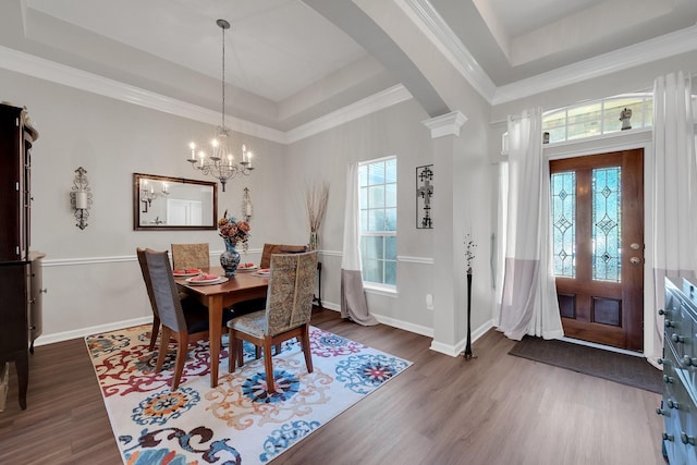 dining space featuring baseboards, arched walkways, a raised ceiling, and wood finished floors