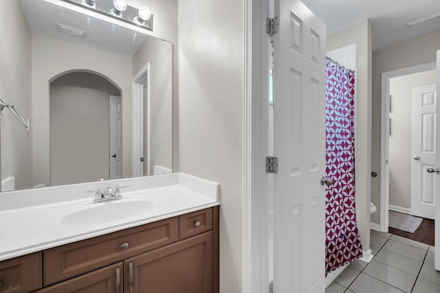 full bathroom with toilet, curtained shower, vanity, and tile patterned floors