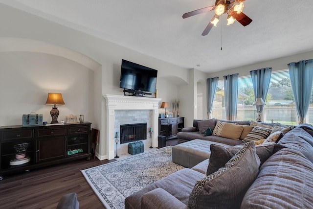 living area featuring dark wood-style floors, a fireplace, and ceiling fan