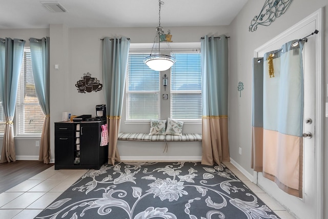 interior space featuring a healthy amount of sunlight, light tile patterned floors, baseboards, and visible vents