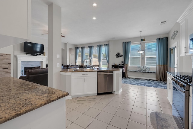 kitchen featuring stainless steel appliances, visible vents, open floor plan, white cabinets, and a sink