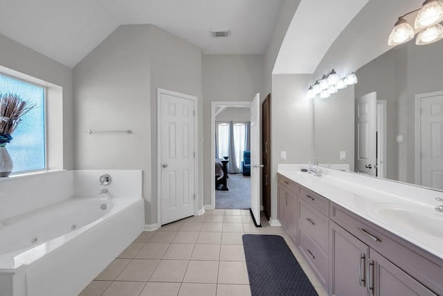 bathroom featuring double vanity, lofted ceiling, visible vents, a sink, and tile patterned flooring