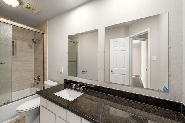 full bath featuring toilet, visible vents, combined bath / shower with glass door, and vanity