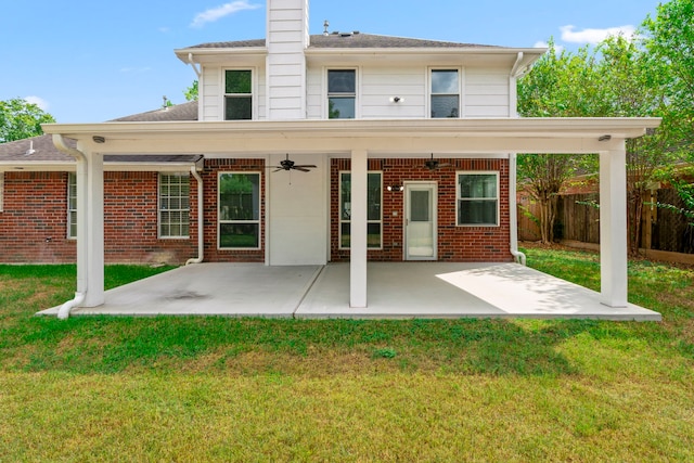 back of house featuring brick siding, a lawn, a patio area, and fence