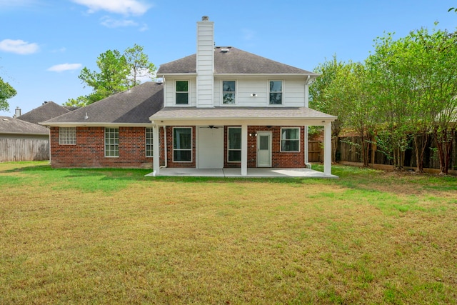 rear view of property with a fenced backyard, brick siding, a yard, a chimney, and a patio area